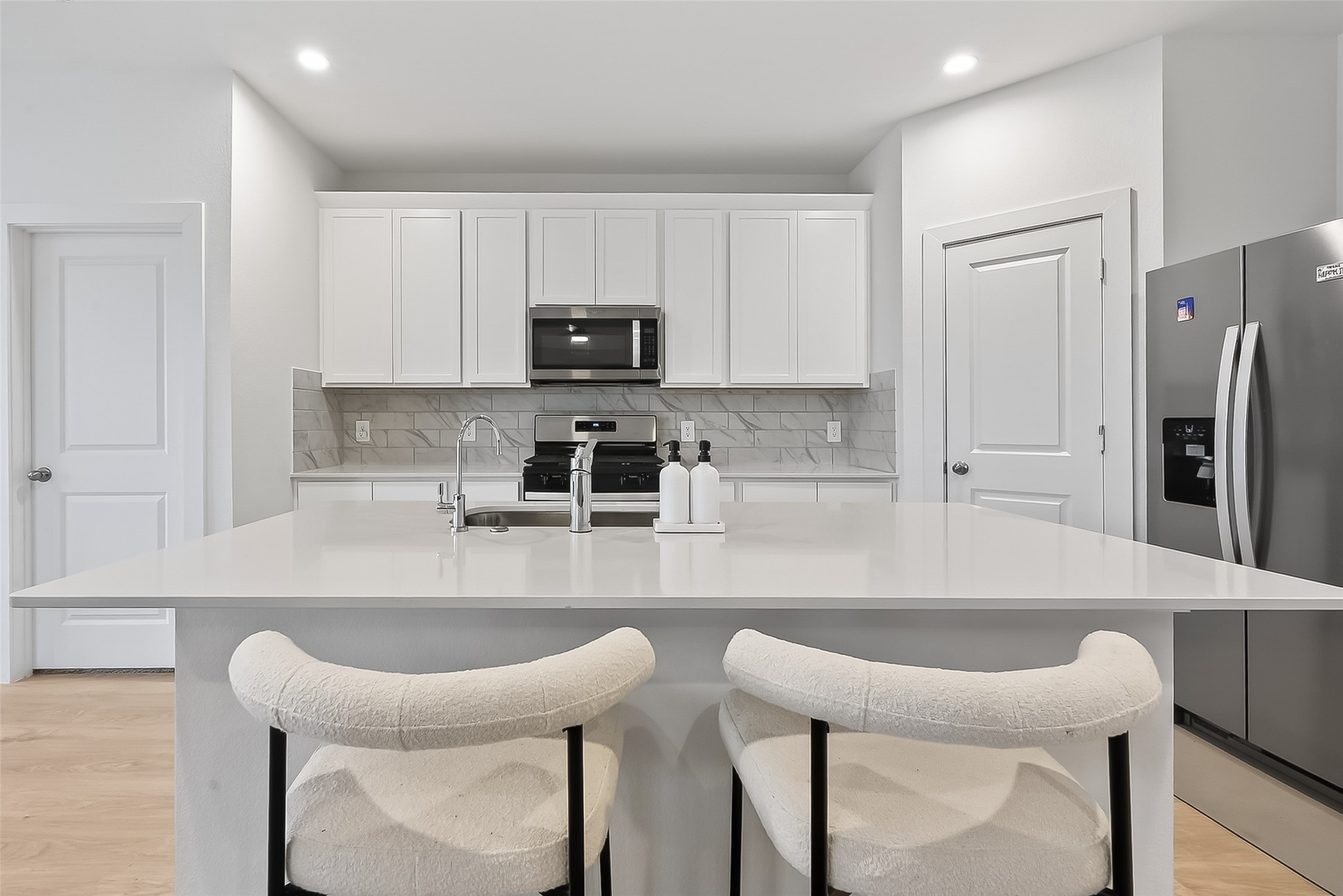 3903 Dodington Ash Drive Fulshear, TX 77441 - Photo 12 of 46 a kitchen with stainless steel appliances a table chairs refrigerator and microwave