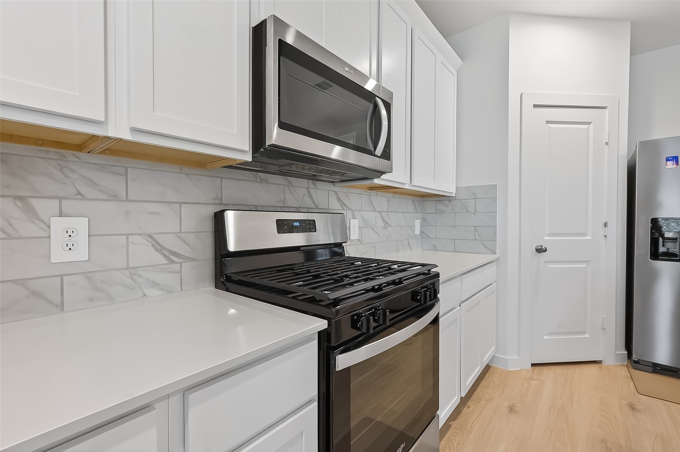 3903 Dodington Ash Drive Fulshear, TX 77441 - Photo 14 of 46 a kitchen with stainless steel appliances a stove a microwave and cabinets