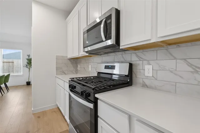 a kitchen with stainless steel appliances granite countertop a stove and a microwave
