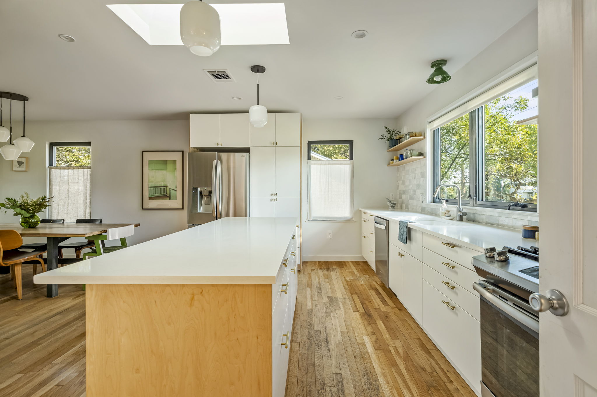618 Denson Drive Austin, TX 78752 - Photo 12 of 35 a large white kitchen with wooden floor and a sink
