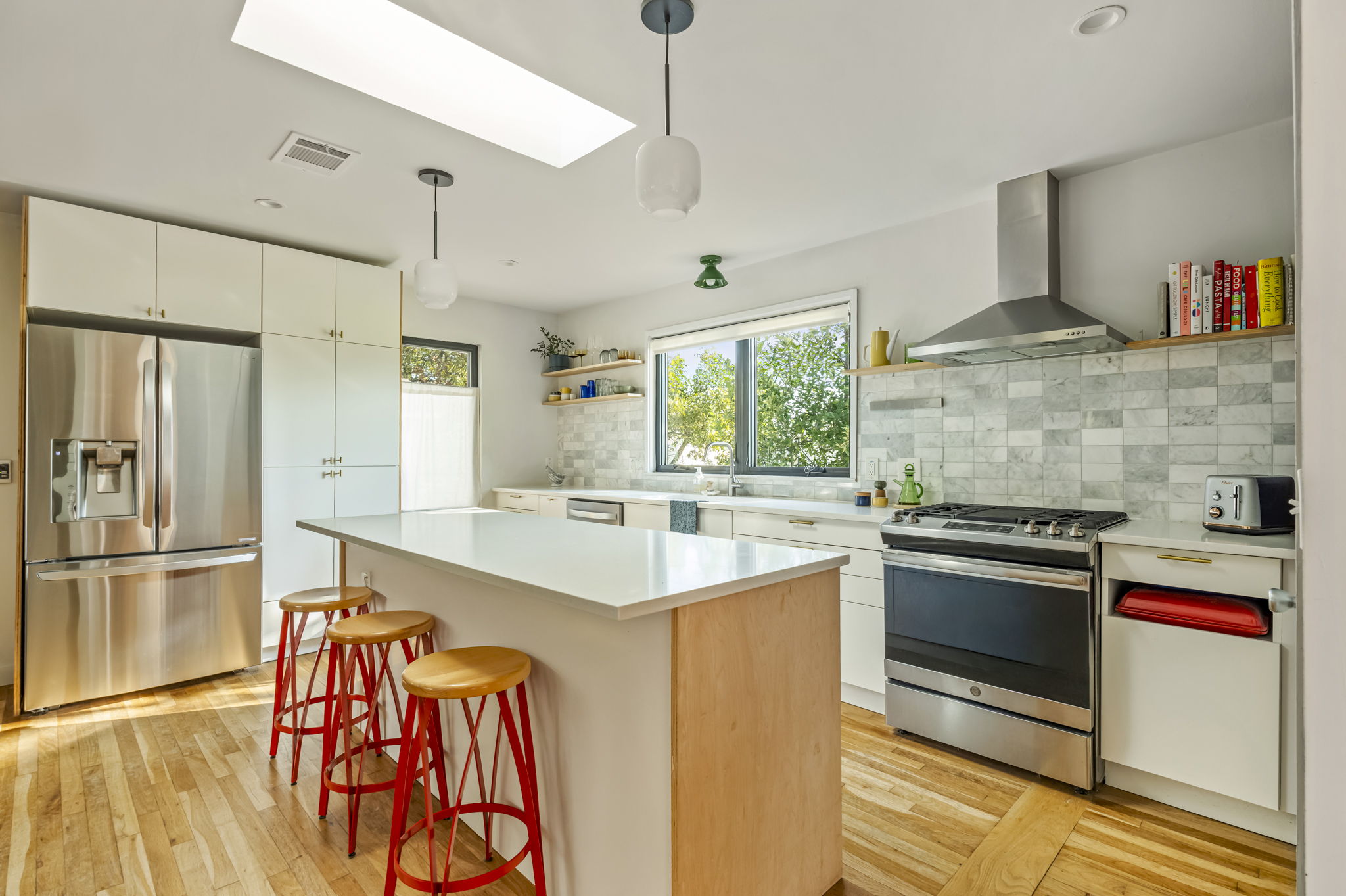 618 Denson Drive Austin, TX 78752 - Photo 10 of 35 a kitchen with stainless steel appliances granite countertop a stove and a refrigerator