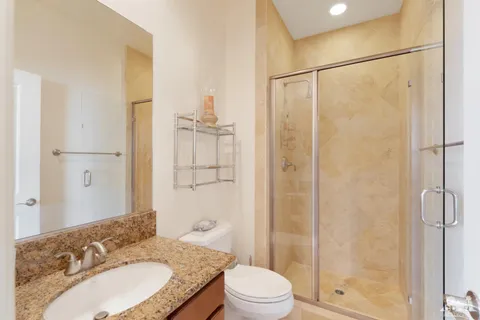 a bathroom with a granite countertop sink toilet and shower