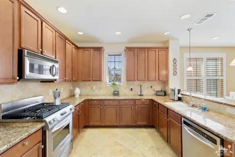 a kitchen with stainless steel appliances granite countertop a sink stove and cabinets