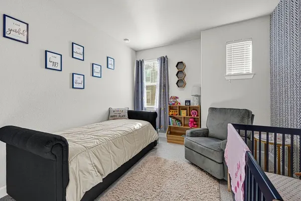 a bedroom with a bed couch and a window