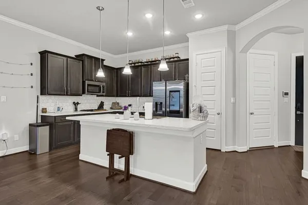 a kitchen with kitchen island granite countertop a sink cabinets and wooden floor