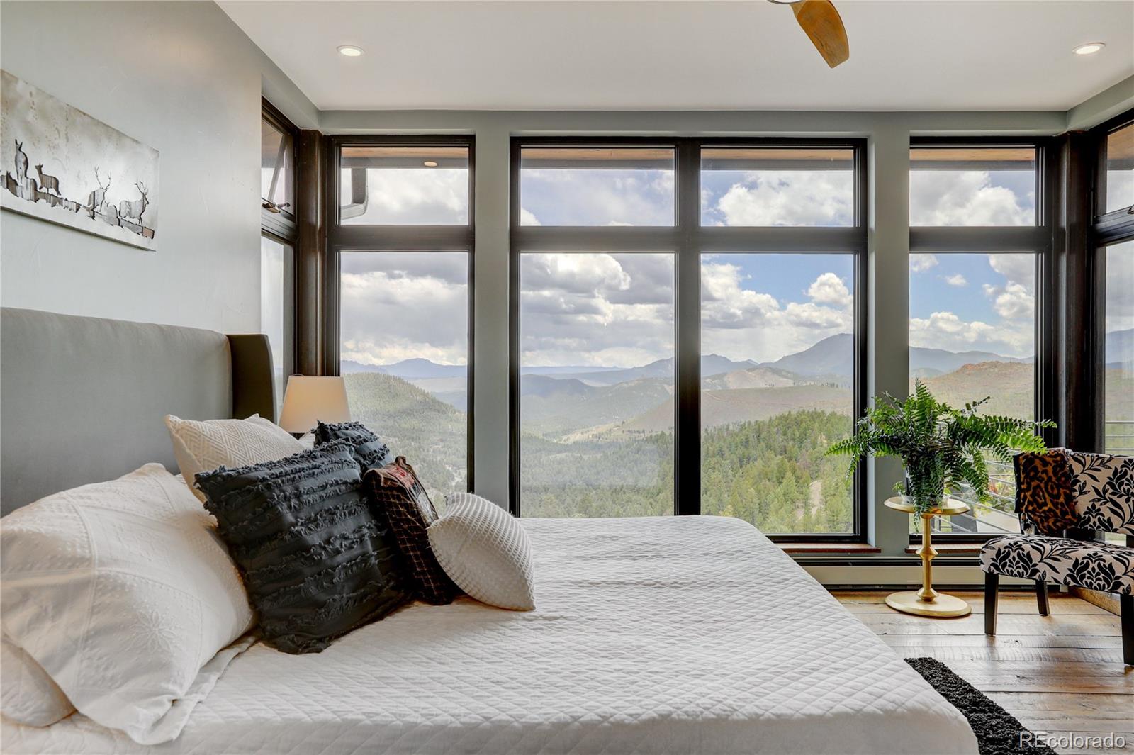 31995 Half Peak Trail Pine, CO 80470 - Photo 15 of 40 a bed sitting in a bedroom next to a large window