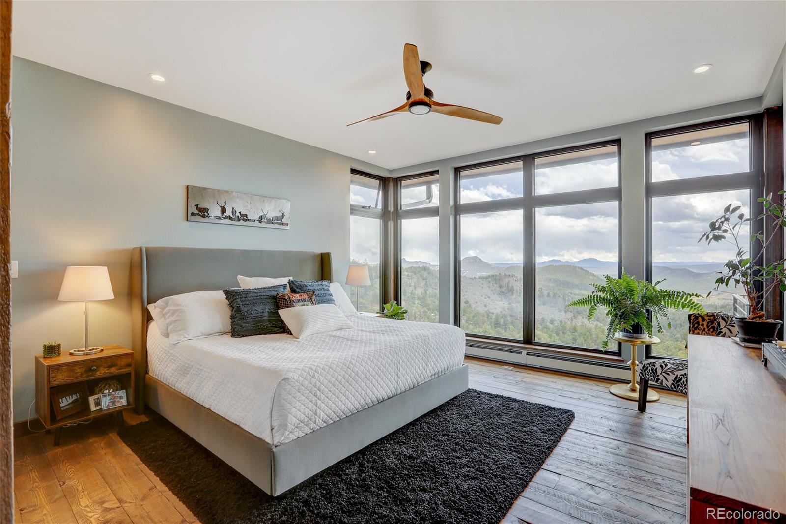 31995 Half Peak Trail Pine, CO 80470 - Photo 16 of 40 a bedroom with a large bed and a potted plant