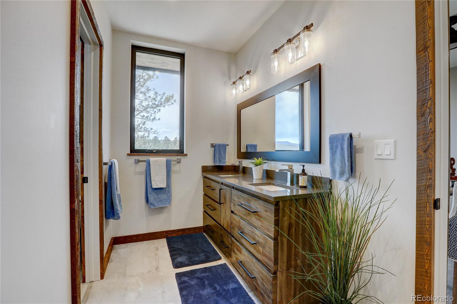 31995 Half Peak Trail Pine, CO 80470 - Photo 22 of 40 a bathroom with a sink a mirror and a window
