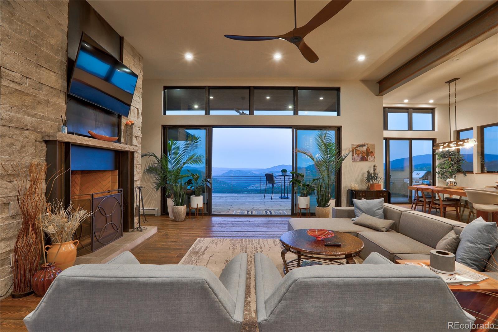 31995 Half Peak Trail Pine, CO 80470 - Photo 3 of 40 a living room with furniture a fireplace and a flat screen tv