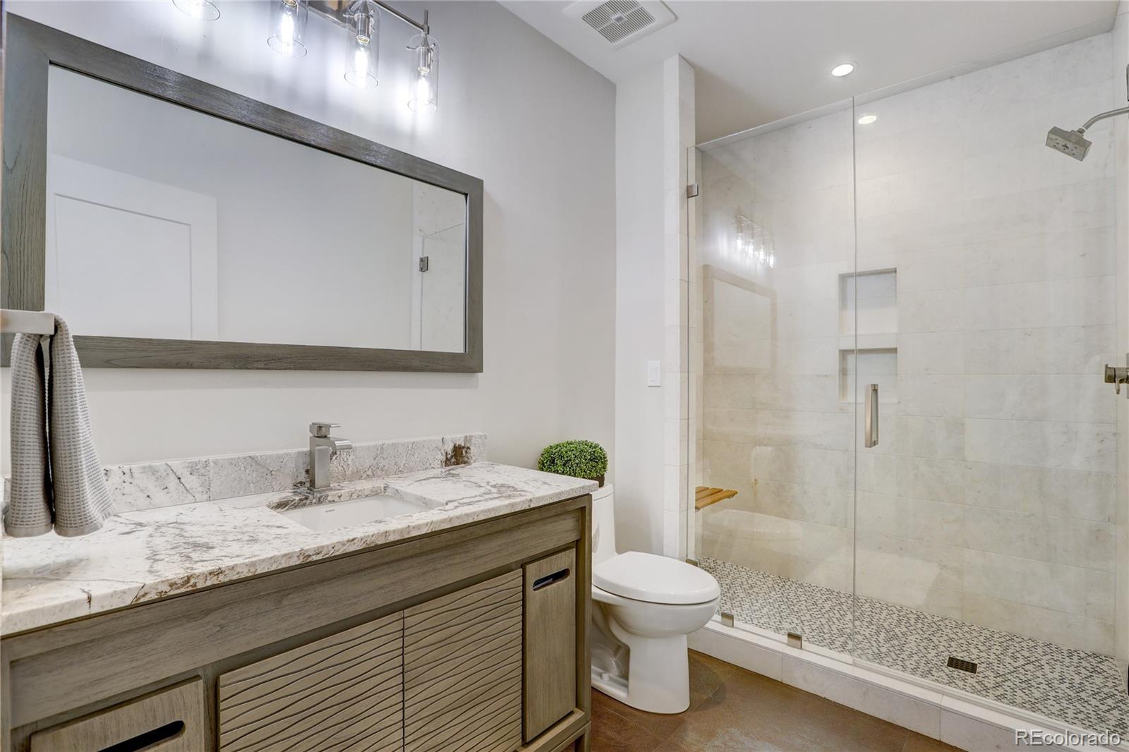 31995 Half Peak Trail Pine, CO 80470 - Photo 31 of 40 a bathroom with a granite countertop sink a toilet and a mirror