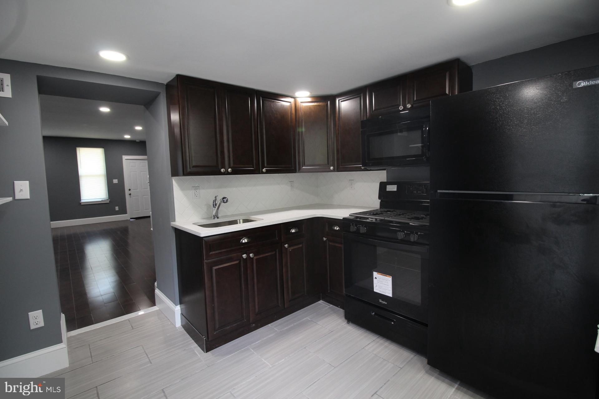 3086 Memphis Street Philadelphia, PA 19134 - Photo 4 of 18 a kitchen with stainless steel appliances kitchen island granite countertop a refrigerator and a sink