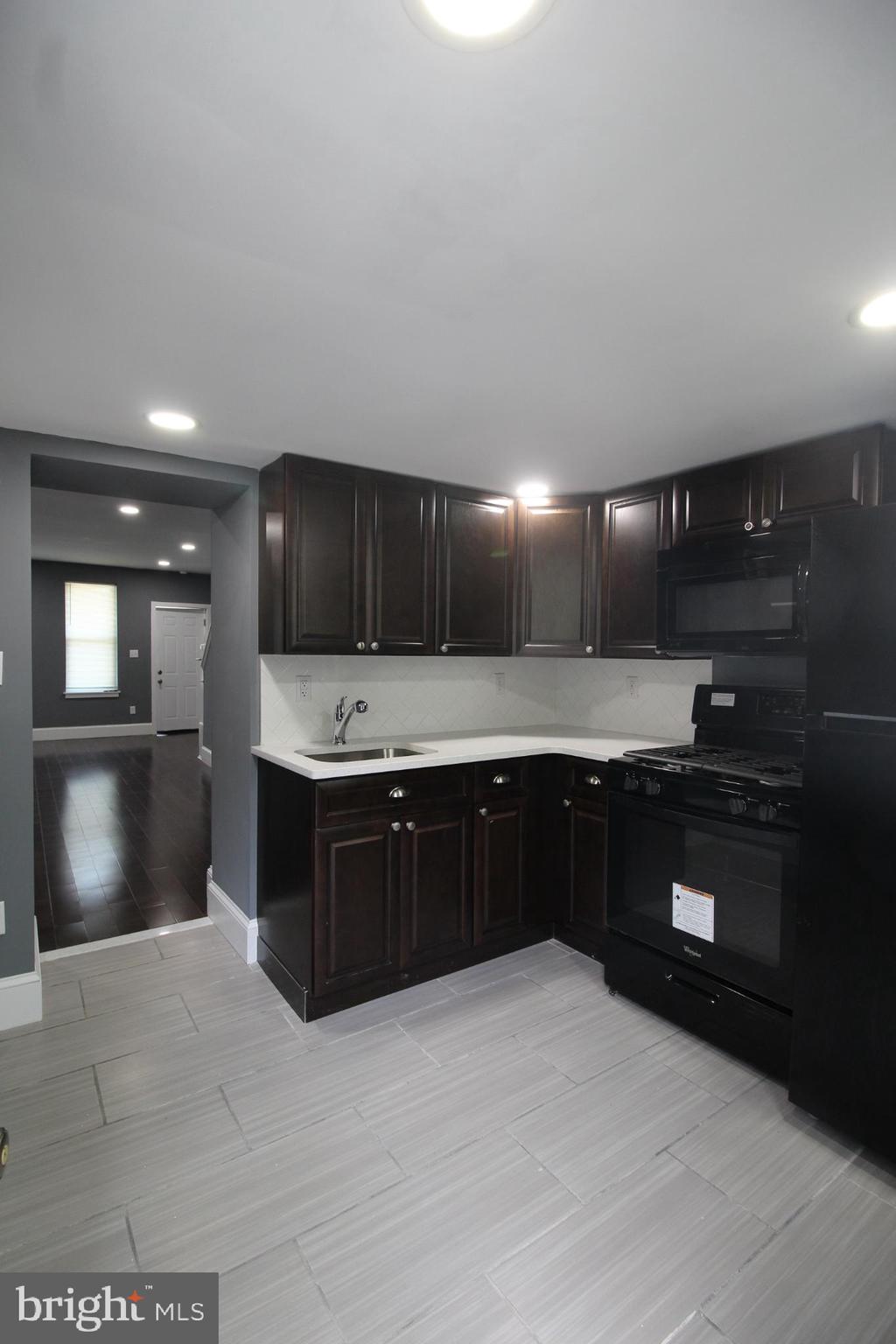 3086 Memphis Street Philadelphia, PA 19134 - Photo 5 of 18 a large kitchen with stainless steel appliances granite countertop a stove a sink and a microwave
