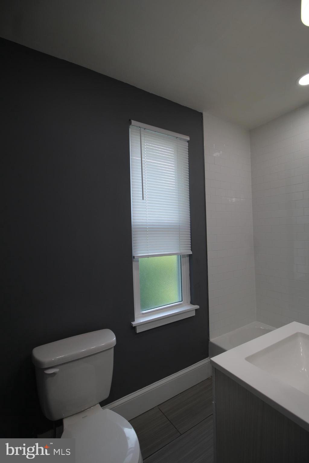 3086 Memphis Street Philadelphia, PA 19134 - Photo 8 of 18 a bathroom with a toilet a sink and a window