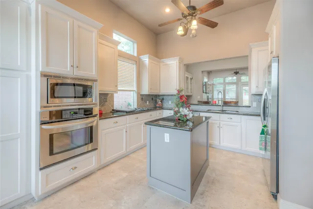 a kitchen with white cabinets appliances and a sink