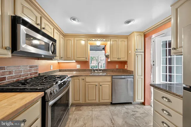 a kitchen with stainless steel appliances granite countertop a stove and a microwave