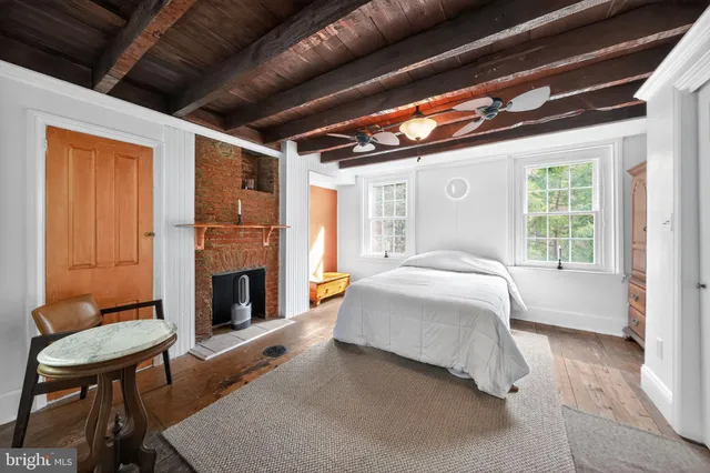 a bedroom with a bed with chair and window