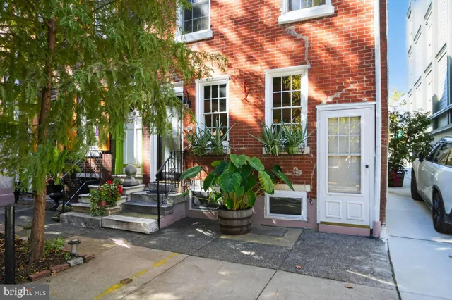 a view of a brick house with a yard and plants