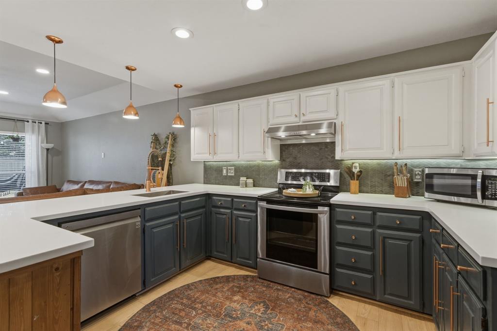 945 Lakeridge Drive Azle, TX 76020 - Photo 14 of 40 a kitchen with stainless steel appliances granite countertop a sink stove and cabinets