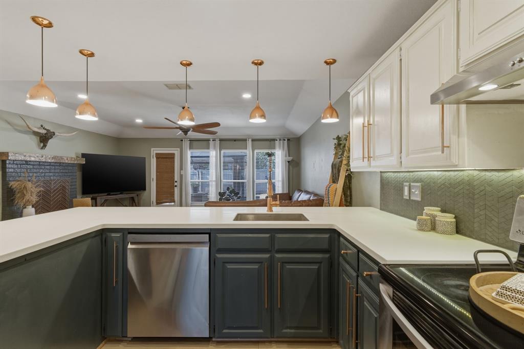 945 Lakeridge Drive Azle, TX 76020 - Photo 15 of 40 a kitchen with a sink and a stove top oven with wooden floor