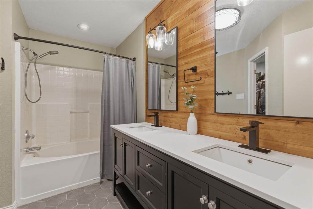 945 Lakeridge Drive Azle, TX 76020 - Photo 22 of 40 a bathroom with a shower sink vanity and mirror