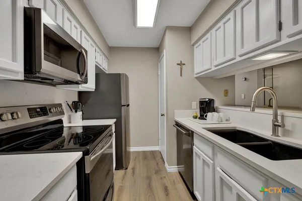 a kitchen with stainless steel appliances granite countertop a sink stove and microwave
