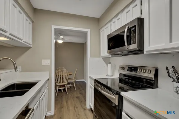 a kitchen with stainless steel appliances a stove a sink and a microwave