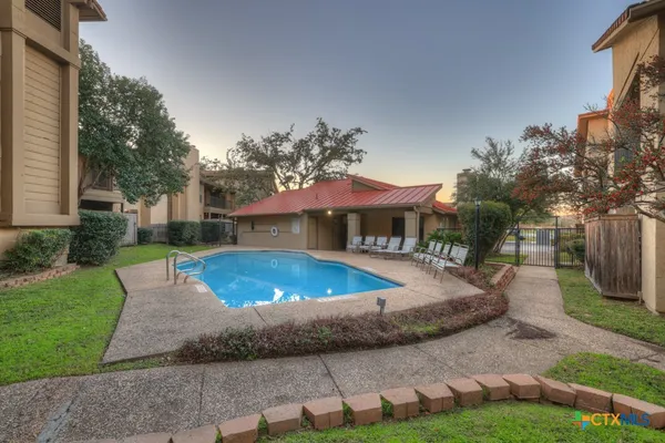 a view of a house with backyard and sitting area