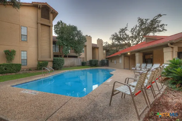 a view of a house with swimming pool and sitting area