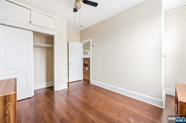 a view of an empty room with wooden floor