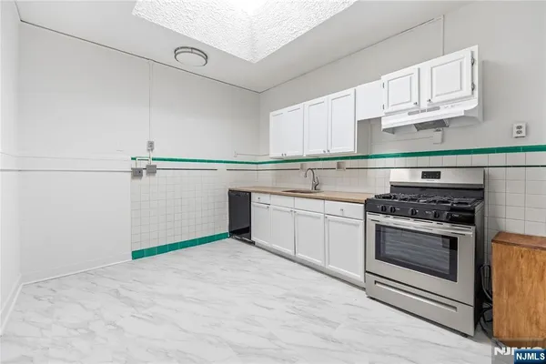a kitchen with stainless steel appliances white cabinets and a sink