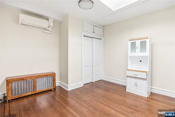 an empty room with wooden floor and closet