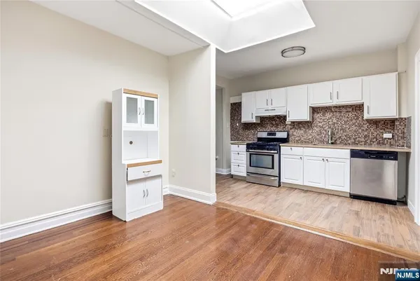 a kitchen with granite countertop a refrigerator and a stove top oven