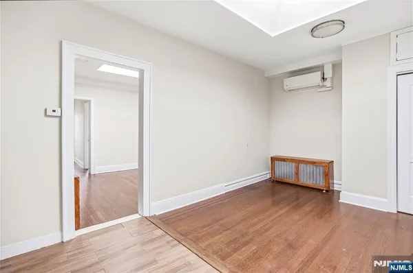 an empty room with wooden floor and a window