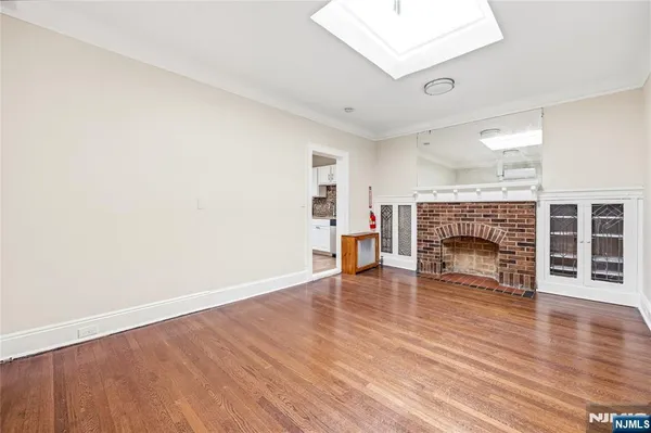 an empty room with wooden floor and fireplace