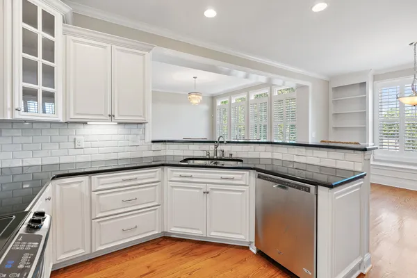a kitchen with granite countertop white cabinets and white appliances