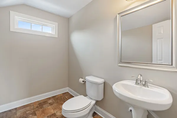 a bathroom with a sink a toilet and mirror