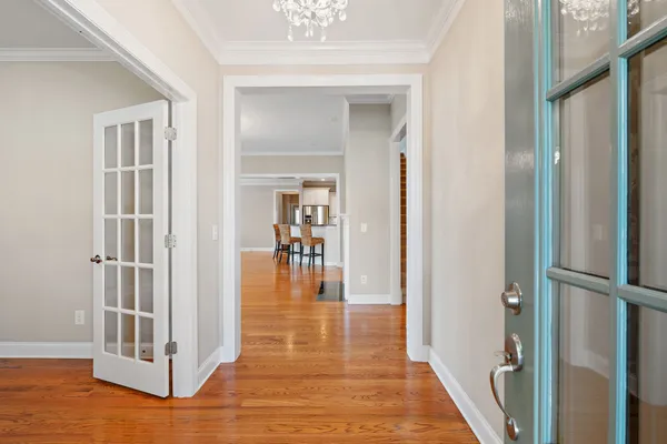a view of a hallway with wooden floor and dining room