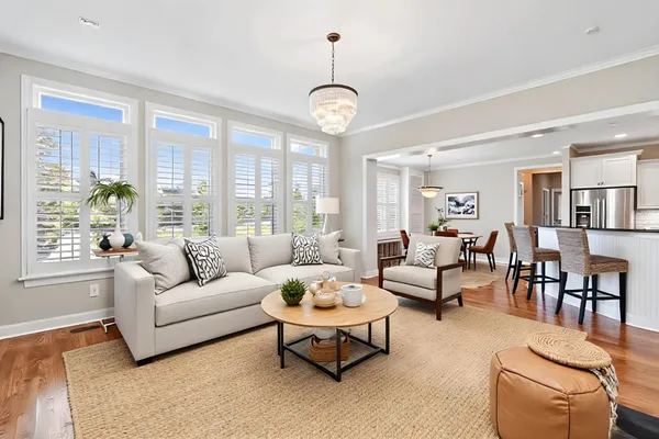 a living room with furniture a large window and a chandelier