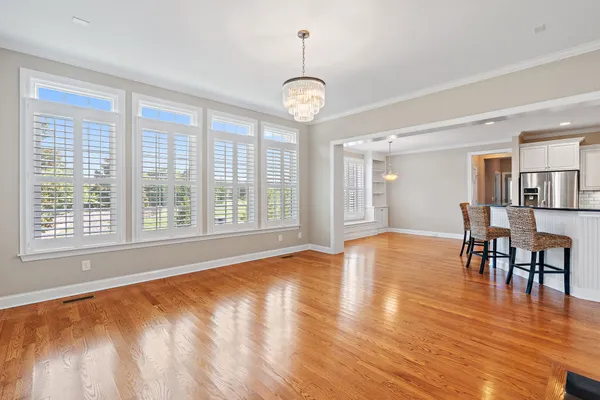 a view of an empty room with window and wooden floor