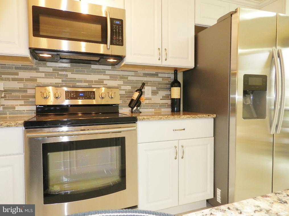 8991 Centerway Road Gaithersburg, MD 20879 - Photo 14 of 30 a kitchen with granite countertop cabinets stainless steel appliances and wooden cabinets