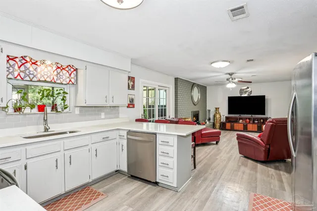 a view of kitchen with stainless steel appliances kitchen island granite countertop a sink and a flat screen tv