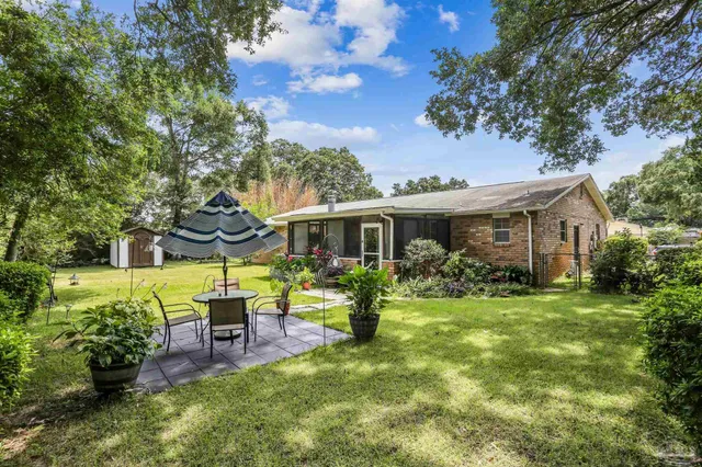 a front view of a house with swing and a table and chairs
