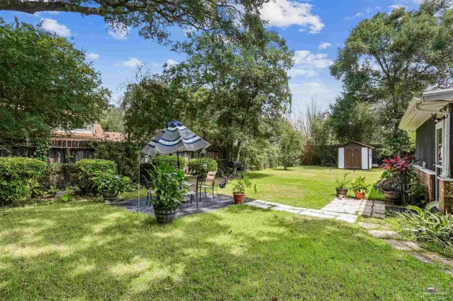 a view of a house with a yard and sitting area