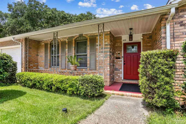 a view of a house with potted plants and a table and chairs