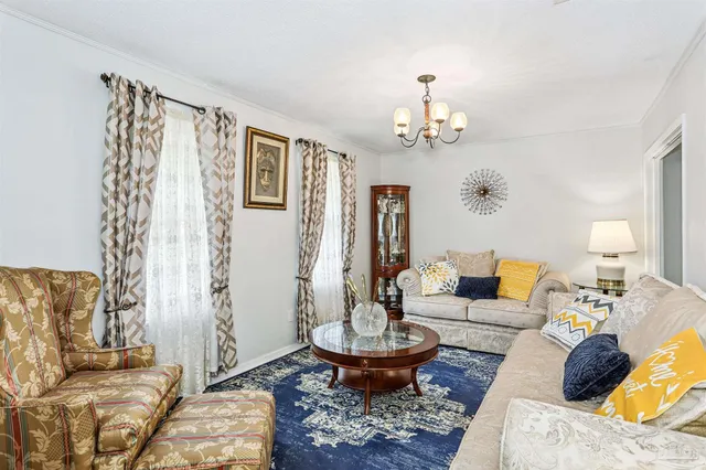 a living room with furniture and a chandelier