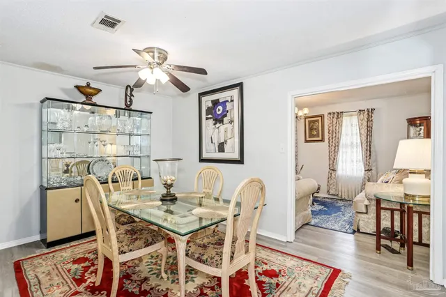 a dining room with wooden floor and a chandelier
