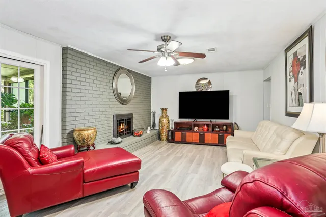 a living room with furniture a flat screen tv and a large window