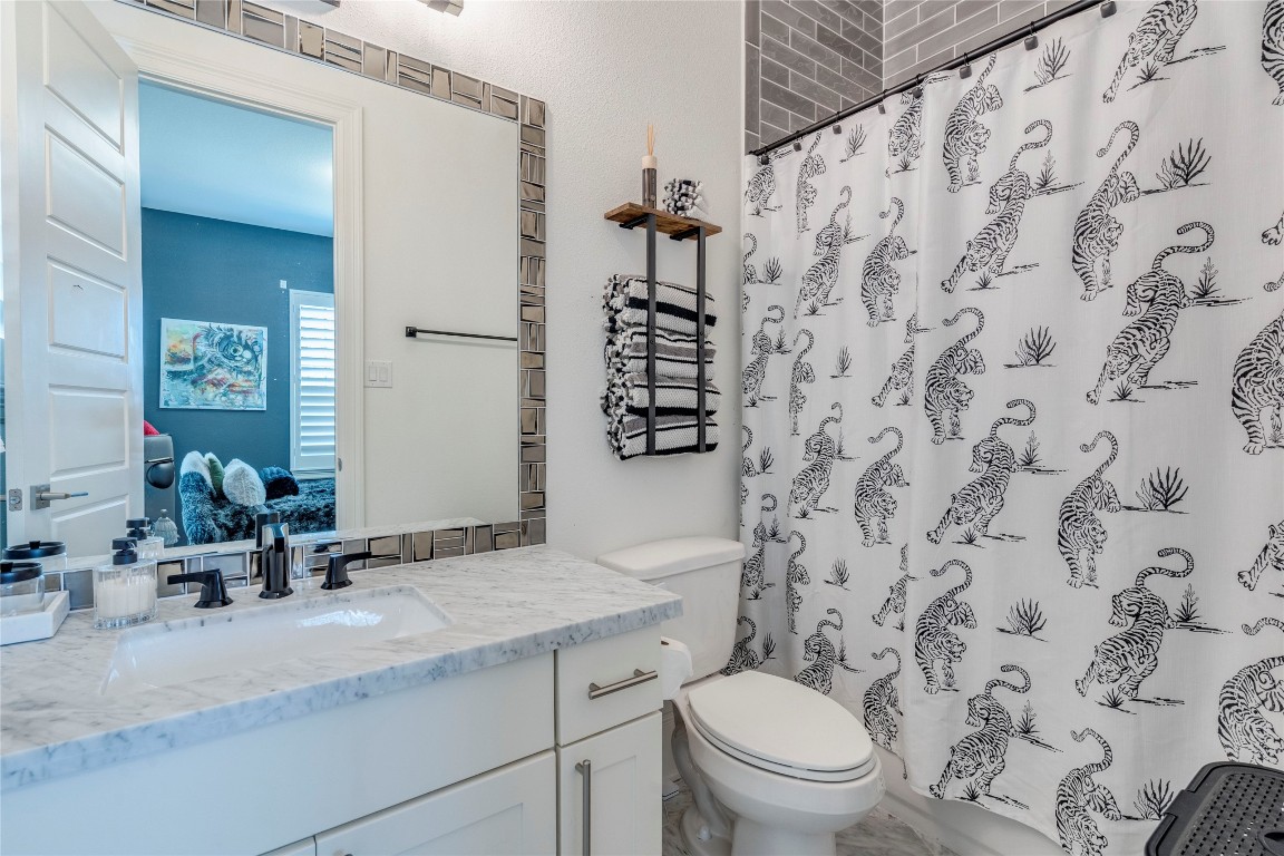 109 Bisset Court Austin, TX 78738 - Photo 21 of 34 a bathroom with a granite countertop sink toilet and mirror