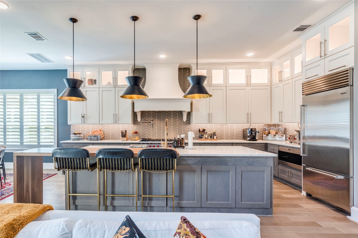 109 Bisset Court Austin, TX 78738 - Photo 10 of 34 a kitchen with stainless steel appliances granite countertop a sink a stove and a wooden floors