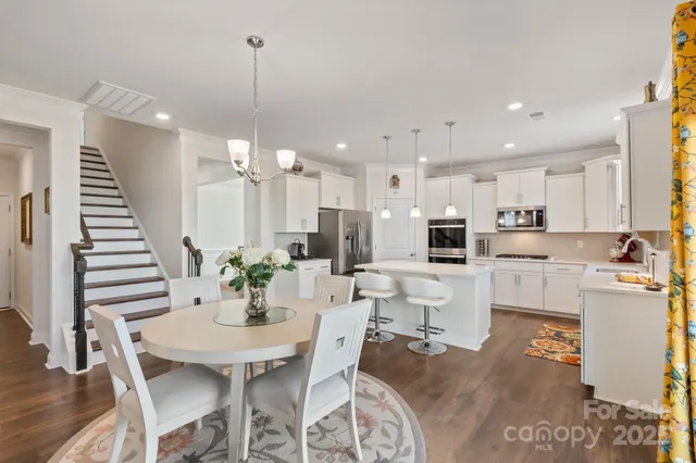 a large kitchen with stainless steel appliances kitchen island granite countertop a refrigerator and a stove top oven